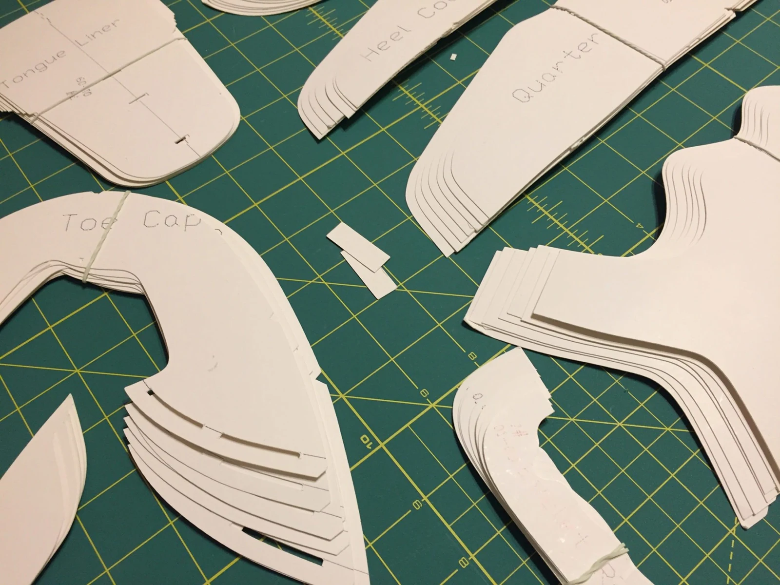 Footwear patterns being prepared on a cutting mat